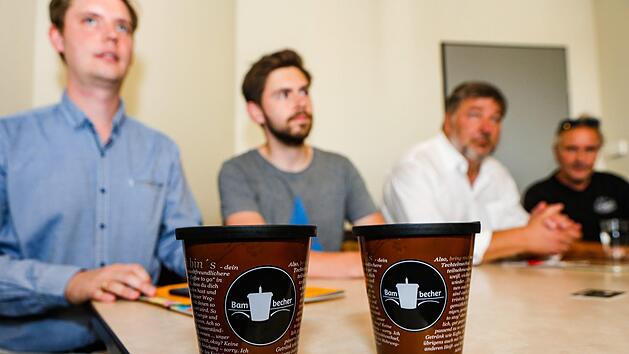 Der "Bambecher" sieht so aus und ist nun in etlichen Gesch&auml;ften in Bamberg zu bekommen. Mit dem  Mehrwegsystem  wollen (von links) Jonas Gl&uuml;senkamp und Andreas Eichenseher von der Initiative, sowie Klaus Stieringer vom Stadtmarketing dem Einwegm&uuml;ll den Kampf ansagen. Thomas Loskarn (rechts) von der gleichnamigen B&auml;ckerei beteiligt sich mit vier seiner Filialen auch daran. Foto: Matthias Hoch