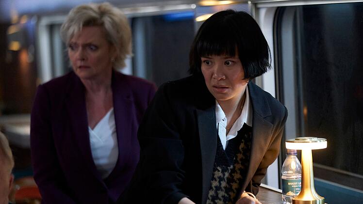 Die Journalistin Rachel Li (Katie Leung, rechts) will als erste &uuml;ber den Hackerangriff berichten. Die britische Verkehrsministerin Liz Draycott (Sharon Small) sorgt sich derweil um ihr Ansehen in der &Ouml;ffentlichkeit.