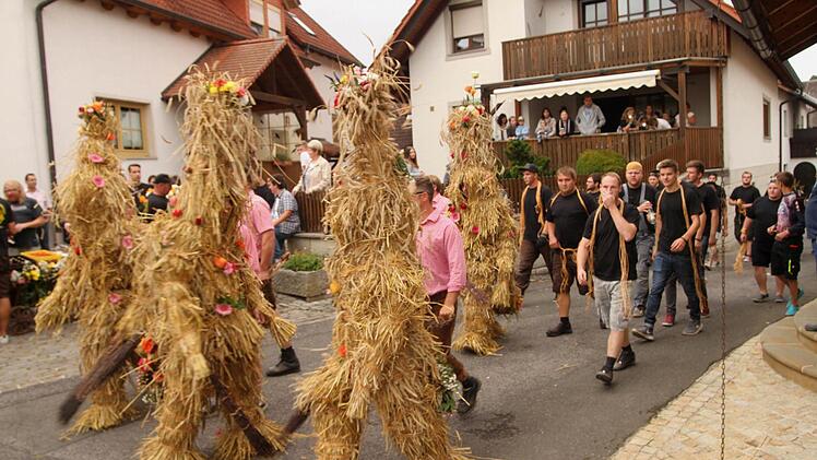 Aufzug der Strohbären auf dem Dorfplatz mit ihren Führern und Helfern.