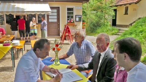 Minister Thorsten Glauber (l.) tr&auml;gt sich im Streitberger Freibad in das Goldene Buch der Marktgemeinde Wiesenttal ein.  Foto: Paul P&ouml;hlmann