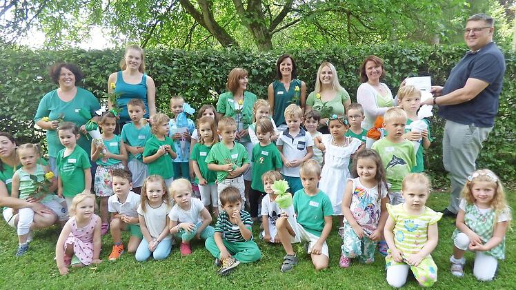 Die Kinder der Kindertagesstätte Stempferhof mit ihren Erzieherinnen und Fachberater Andreas Brunner (r.), der die Zertifizierungsurkunde an Kita-Leiterin Christine Kulka-Marcks übergibt.  Foto: Thomas Weichert