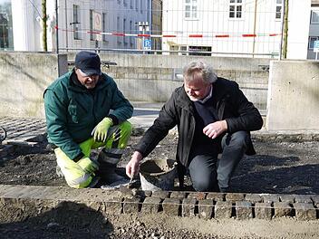 Beim Verfugen der Randsteine überlässt Arbeiter Sergej Akutin (links) ausnahmsweise dem Chef, Bernhard Ledermann, die Kelle. Foto: Ulrike Nauer