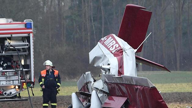 Ein abgest&uuml;rztes Propellerflugzeug liegt auf einem Feld neben einem Feuerwehrwagen. Bei dem Unfall, der sich westlich der Autobahn 5 ereignete, sind nach Angaben eines Polizeisprechers zwei Menschen ums Leben gekommen. Foto: Juergen Strieder/Sueddeutschen Mediengesellschaft/dpa