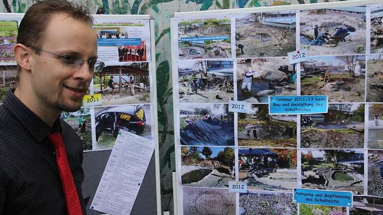 Lehrer Martin Wolf leitet die Schulgarten-Initiative. An einer Bildertafel waren Stationen des Schulgarten-Baus dokumentiert.  Foto: Helmut Will