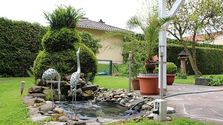 Zier-Reiher aus Metall schmücken den kleinen Gartenteich. Foto: Benedikt Borst