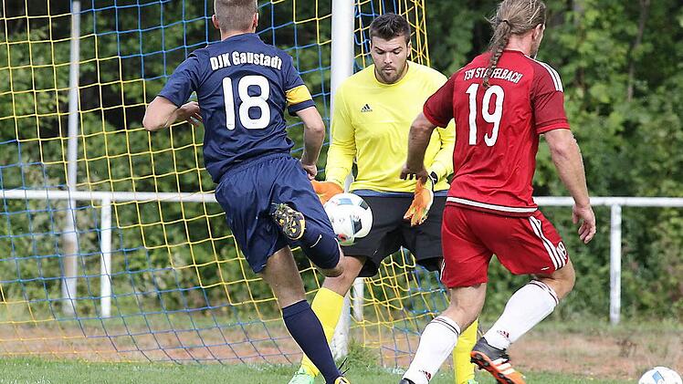 Der Staffelbacher Torwart Daniel Schirmer fängt den Ball; rechts Jürgen Postler vor dem DJKler Christopher Montag