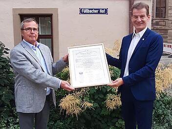 Rolf  Venbrocks (links) übergibt die Gründungsurkunde des Lions Club Bad Kissingen an Michael Rendl:  Das historische Dokument aus dem Jahr 1961 wird jeweils vom amtierenden Präsidenten verwahrt. Foto:  Lars Streiberger