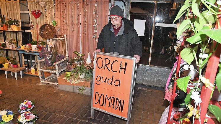 Anton Lamprecht mit einem Schild, auf dem die Gärtnerei im Sommer für "Orch guda Domadn" geworben hat.