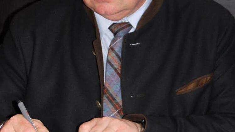 Staatssekretär Gerhard Eck trägt sich ins Goldene Buch der Stadt Münnerstadt ein.