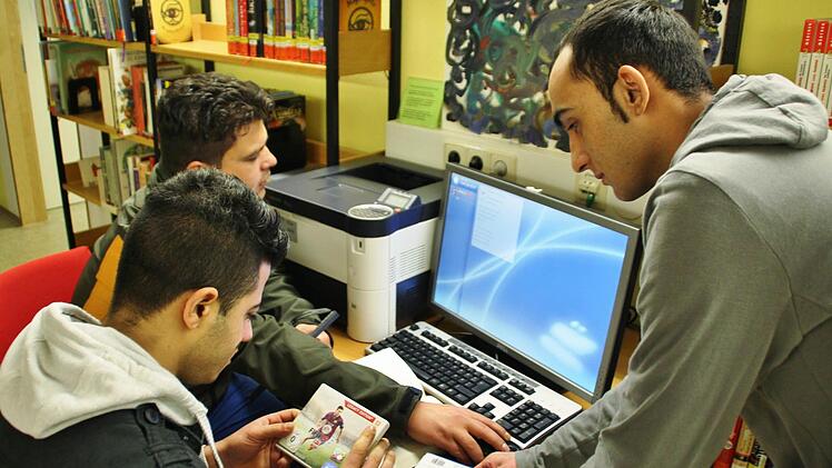 Auch Internetanschluss und Drucker gibt's in der Stadtbücherei Bad Kissingen lernen die Flüchtlinge (von links) Nasdulla Baber, Elgude Ahmed und Najeeb Kakar. Foto: Werner Vogel