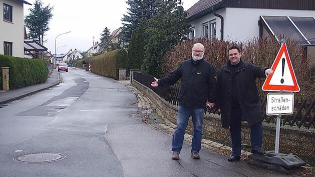 Die beiden Stadträte (von links) Winfried Lebok und Michael Zwingmann verweisen auf die arg in Mitleidenschaft gezogene Fahrbahnoberfläche der Frankenstraße.  Foto: Heike Schülein