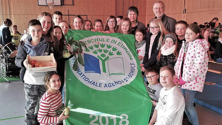 Mit dem Hissen der Umweltfahne feierte die Umweltgruppe der Grundschule Burkardroth gemeinsam mit Schulleiterin Claudia Klaas und Bürgermeister Waldemar Bug (beide rechts hinten) das zehnjährige Jubiläum als "Umweltschule in Europa". Foto: Sigismund von Dobschütz