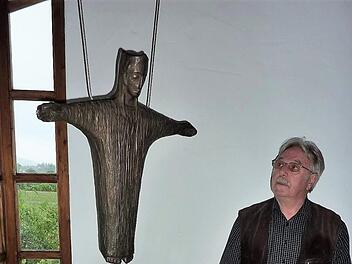 Blick in das schlichte Innere der Friedenskapelle mit einem in Bronze gearbeiteten Christuskönig. Als Altar dient ein Sandsteinquader. Dahinter stehen Teile des zerborstenen Grenzzaunes. Seit 25 Jahren ist Willi Bischoff Vorsitzender des Kapellenbauvereins.