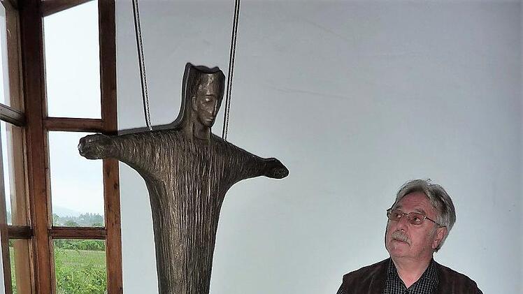 Blick in das schlichte Innere der Friedenskapelle mit einem in Bronze gearbeiteten Christuskönig. Als Altar dient ein Sandsteinquader. Dahinter stehen Teile des zerborstenen Grenzzaunes. Seit 25 Jahren ist Willi Bischoff Vorsitzender des Kapellenbauvereins.