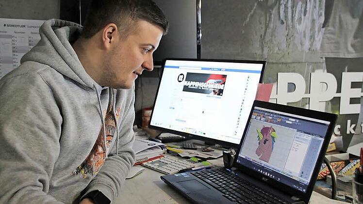 Fabian Schlund sitzt an seinem Computer und wandelt gerade eine Vorlage in ein Stickmuster um.  Fotos: Sarah Stieranka