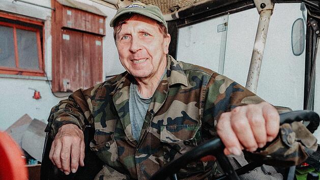 Martin Tremel kommt auf seinem Traktor vom Arbeitseinsatz im Wald zur&uuml;ck.