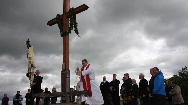 Pfarrer Michael Gehret segnet das neue Kreuz am Rodenstein. Fotos: Galster