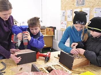 Sabine und Emil Michel, sowie Laura und Kevin Weinberger (von links) arbeiten an ihren Insektenhotels. Foto: Klopf