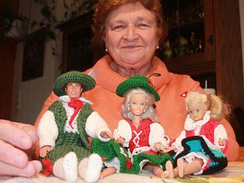 Gertrud Tischler mit drei ihrer zahlreichen Barbie-Puppen, für die sie selbst Kleider häkelte: Neben der Hellwig und ihrer Tochter in Trachtenjankern sitzt der einzige Ken ihrer Sammlung. Foto: Matthias Einwag