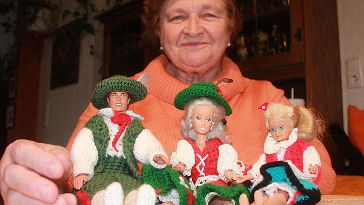 Gertrud Tischler mit drei ihrer zahlreichen Barbie-Puppen, für die sie selbst Kleider häkelte: Neben der Hellwig und ihrer Tochter in Trachtenjankern sitzt der einzige Ken ihrer Sammlung. Foto: Matthias Einwag