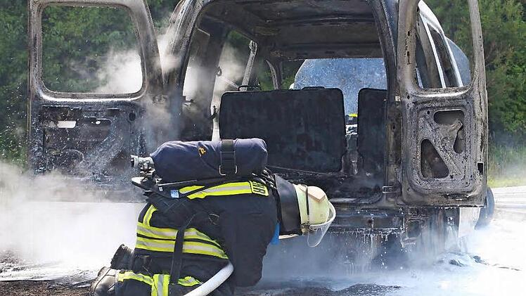 Eine Feuerwehrmann löscht den Unterboden des ausgebrannten VW-Caddy. Fotos: Thomas Heuchling