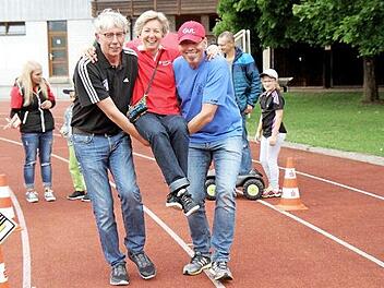 Gerd Ankermann und Jörg Allerdissen von der Turnerschaft tragen Beate Brandner von der Sparkasse auf Händen.  Fotos: Richard Sänger