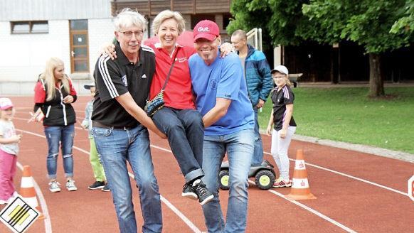 Gerd Ankermann und Jörg Allerdissen von der Turnerschaft tragen Beate Brandner von der Sparkasse auf Händen.  Fotos: Richard Sänger