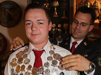 Schützenkönig Michael Winkler bekommt die Königskette umgehängt.   Foto: Sonja Adam