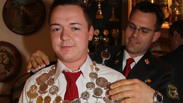 Schützenkönig Michael Winkler bekommt die Königskette umgehängt.   Foto: Sonja Adam