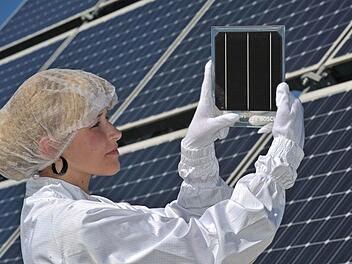 In einer Fabrik der Bosch Solar Energy AG präsentiert eine Mitarbeiterin in Arnstadt (Thüringen) eine Solarzelle. Jetzt steigt Bosch aus der Solarbranche aus. Foto: Martin Schutt/dpa