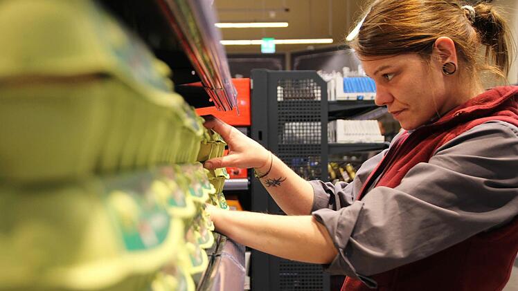 Edeka-Mitarbeiterin Sarah Hamilton räumt die Regale ein. Foto: Christian Bauriedel