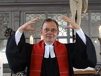 Pfarrer Manfred Greinke gebärdet das Wort "Pfingsten. Es setzt sich zusammen aus den Gebärden für die Worte "Heiliger Geist" und "kommen". Foto: Johanna Eckert