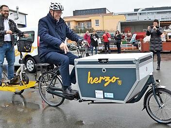 Bürgermeister German Hacker chauffiert das Lastenrad, mit Christian Stöcker als "Ballast" auf dem Anhänger.  Foto: Bernhard Panzer