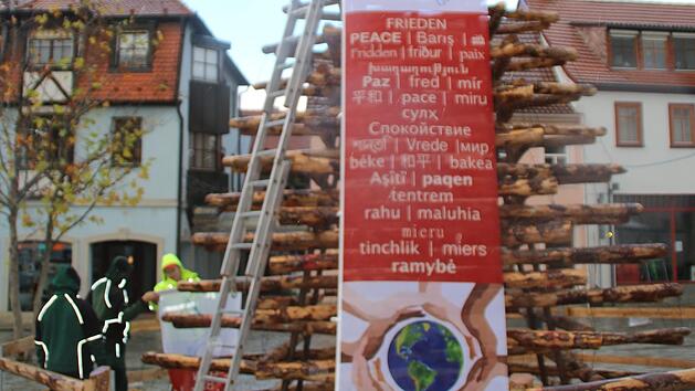 Bei einsetzendem Regen stellt die Lebenshilfe den "Baum des Friedens" am Hammelburger Viehmarkt auf.