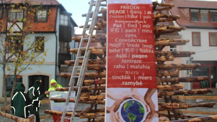 Bei einsetzendem Regen stellt die Lebenshilfe den "Baum des Friedens" am Hammelburger Viehmarkt auf.