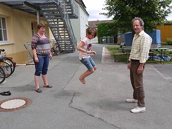 Bea Wirth steht mit Martin Vogel beim "Gummihupf" für ihre Tochter Svea. Die "Ferienmacher" wollen das alte Spiel wieder bekannt machen.   Fotos: Lindner