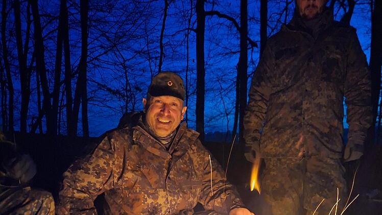 Die Obergefreiten der Reserve Th&uuml;ncher (kniend) und M&uuml;ller w&auml;rmen sich am Feuer, das sie mit einfachen Mitteln selbst entz&uuml;nden mussten.