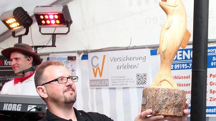 Vorsitzender Rainer Haagen freut sich über den hölzernen Karpfen.