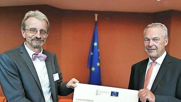 Wolfram Salzer (links) und Neustadts Oberbürgermeister Frank Rebhan mit der Urkunde des Europadiploms, der Einstiegsstufe für den Europapreis. Foto: privat