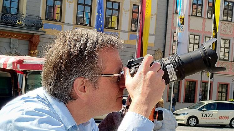 Olaf Huth, Professor an der Fakultät Design (links) dokumentiert mit dem Fotoapparat, wie ein  Team der Hochschule Coburg das Denkmal von Prinz Albert auf dem Marktplatz scannt.  Die große Pappe dient als Schutz vor den Strahlen des mobilen Scanners.Foto: Jochen Berger