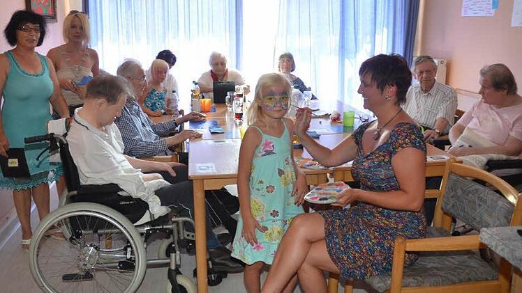Die Kinder hatten ihre Freude beim Schminken, während die Senioren sich beim Sommerfest nicht nur von Musik unterhalten ließen, sondern auch selbst Spiele in die Hand nahmen und Spaß hatten. Die Pflegedienstleitung, Viola Förtsch (2.v.l.) und Cornelia Zänker waren mit Losverkauf beschäftigt.  Foto: K.-H. Hofmann