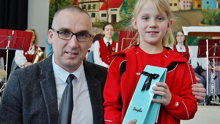 Hanna Walkenhorst nahm stellvertretend für ihre U12-Damenmannschaft vom TSV Aschach ein Geschenk vom 2. Bürgermeister Andreas Sandwall entgegen. Foto: Sigismund von Dobschütz