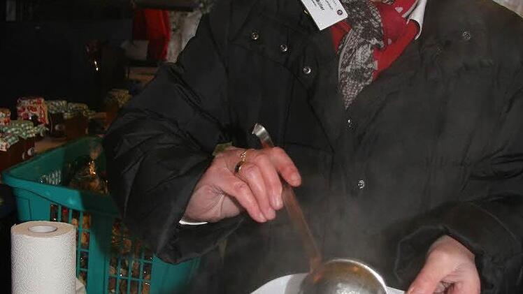 Rosi Müller  schenkt heißen Eintopf aus.