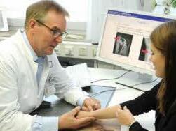 Prof. Raymund Horch, Direktor der Plastisch- und Handchirurgischen Klinik des Uni-Klinikums Erlangen, untersucht Patientin Carina fünf Jahre nach der erfolgreichen Therapie.  Foto: Uni-Klinikum Erlangen