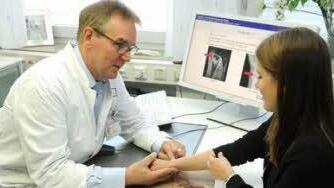 Prof. Raymund Horch, Direktor der Plastisch- und Handchirurgischen Klinik des Uni-Klinikums Erlangen, untersucht Patientin Carina fünf Jahre nach der erfolgreichen Therapie.  Foto: Uni-Klinikum Erlangen