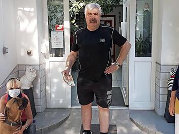 Freddy Winkler übergibt das Geld, der gut erzogene Bordeaux-Doggen-Rüde "Domingo" lässt die Spende nicht aus den Augen.  Foto: privat