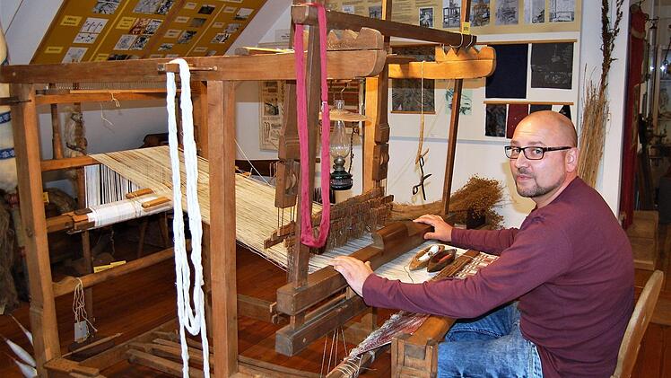 Peter Brust, zweiter Vorsitzender des Heimatvereins, versucht sich am alten Webstuhl. Foto: Sigismund von Dobschütz