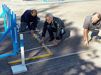 Die Abmessungen müssen genau stimmen. ADAC-Beauftrager Heinrich Muth, Turnierleiter Stefan Kronewald und Organisator Gernot Riemey (von rechts) beim Parcours-Aufbau. Foto: Rolf Pralle