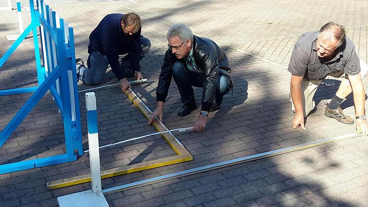Die Abmessungen müssen genau stimmen. ADAC-Beauftrager Heinrich Muth, Turnierleiter Stefan Kronewald und Organisator Gernot Riemey (von rechts) beim Parcours-Aufbau. Foto: Rolf Pralle