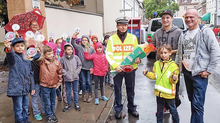 Die Schüler der Klasse 2 b der Wunderburgschule bedanken bei rücksichtvollen Autofahrern. Mit im Bild ein Verkehrserzieher der Polizei sowie ein Fahrlehrer mit seinem Schüler, die sich an die Geschwindigkeitsbegrenzung vor dem Schulgebäude gehalten hatten.  Foto: RiegerPress